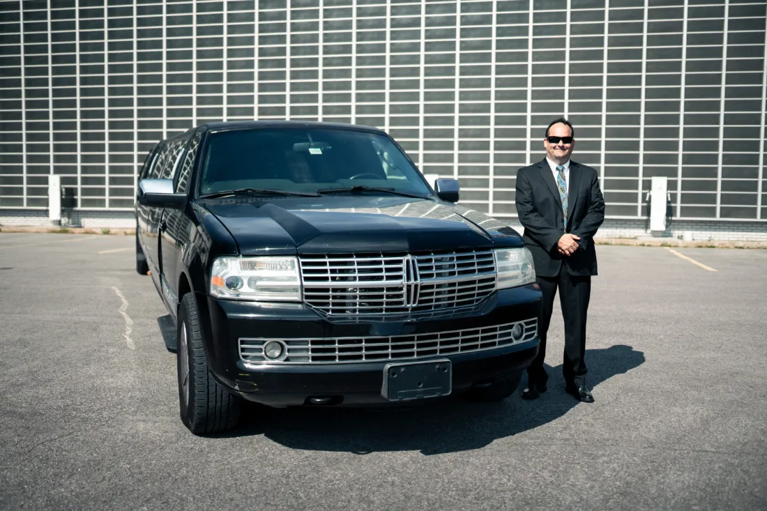 Chauffeur standing beside a black Lincoln Navigator in the Bay Area