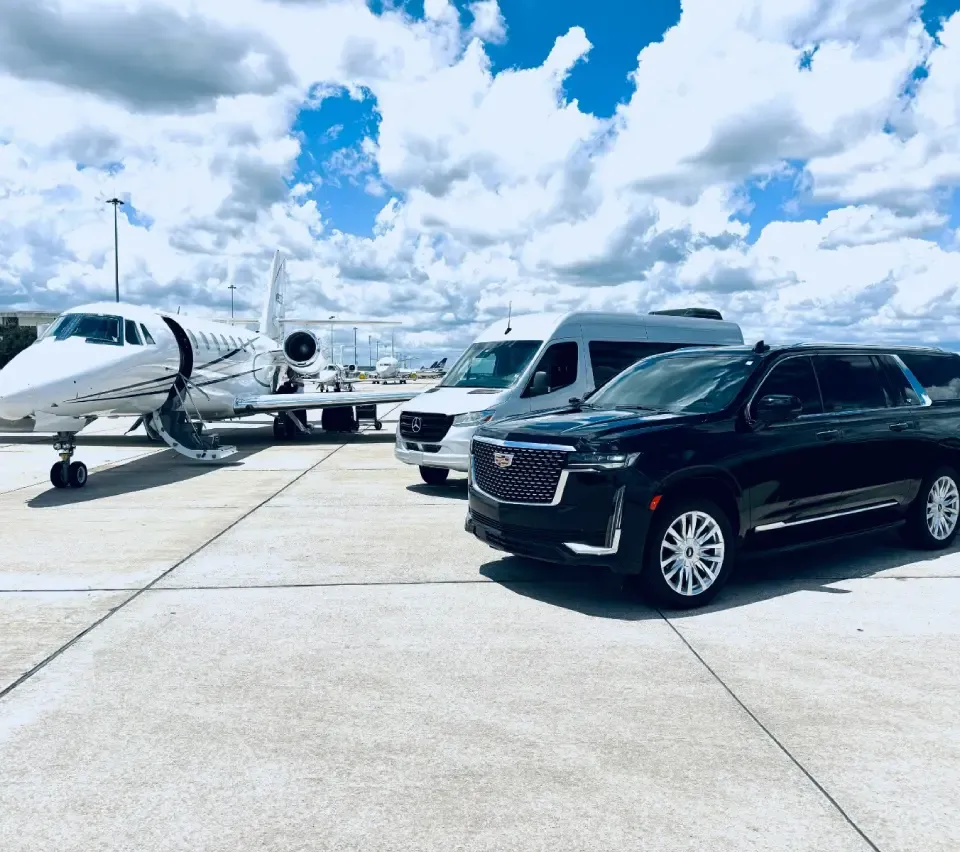 Black SUV and Sprinter parked planeside at a private jet terminal near San Francisco