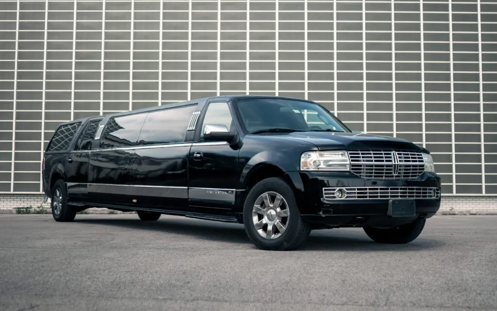 Black Lincoln Navigator stretch limo side view in a parking lot