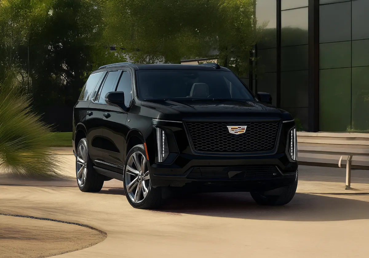 Black Cadillac Escalade SUV parked outside a modern building for chauffeur service
