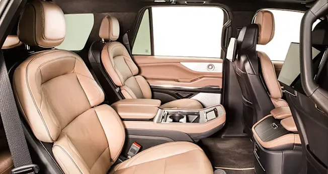 Executive SUV interior with tan leather captain chairs and second-row seating