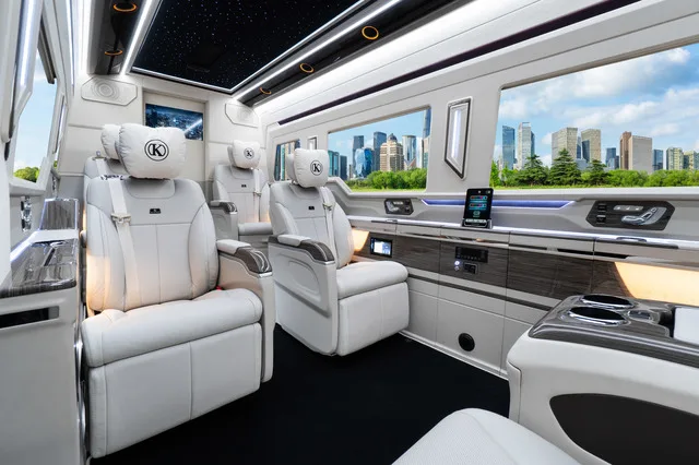 Jet Sprinter interior with white leather reclining captain seats and wood trim