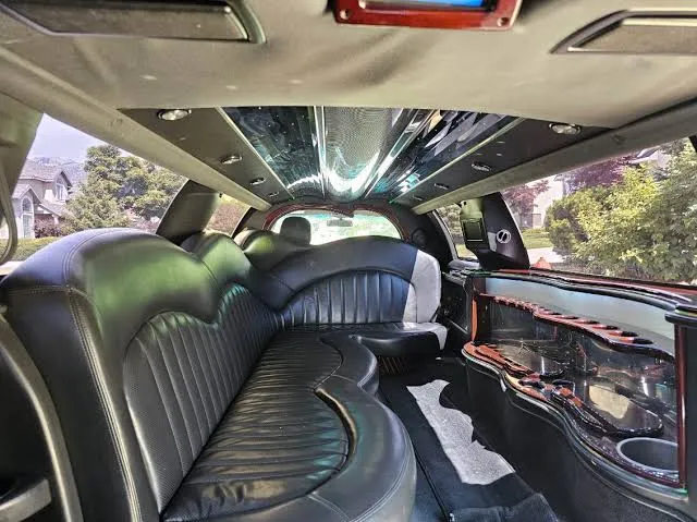 Lincoln stretch limo interior with black leather bench seats and bar area