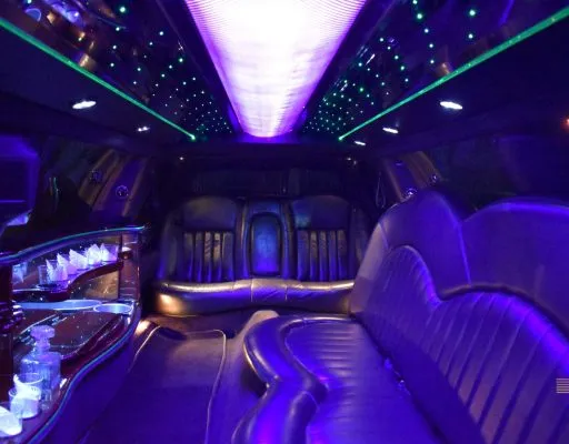 Lincoln stretch limo interior with purple LED ceiling lights and wraparound leather seating