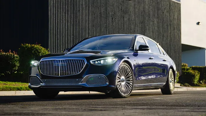 Mercedes-Maybach sedan with its signature chrome grille parked outside a modern building