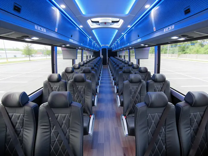 Motor coach interior with black leather seats and blue LED ceiling lights