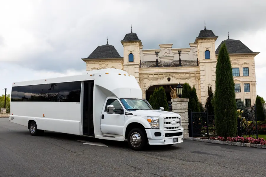 White 30 passenger party bus outside an event venue