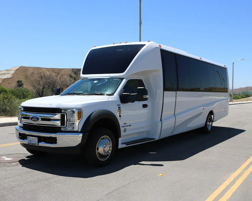 White party bus parked on a sunny street